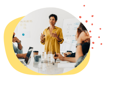 A woman facilitating a discussion with her team in a conference room
